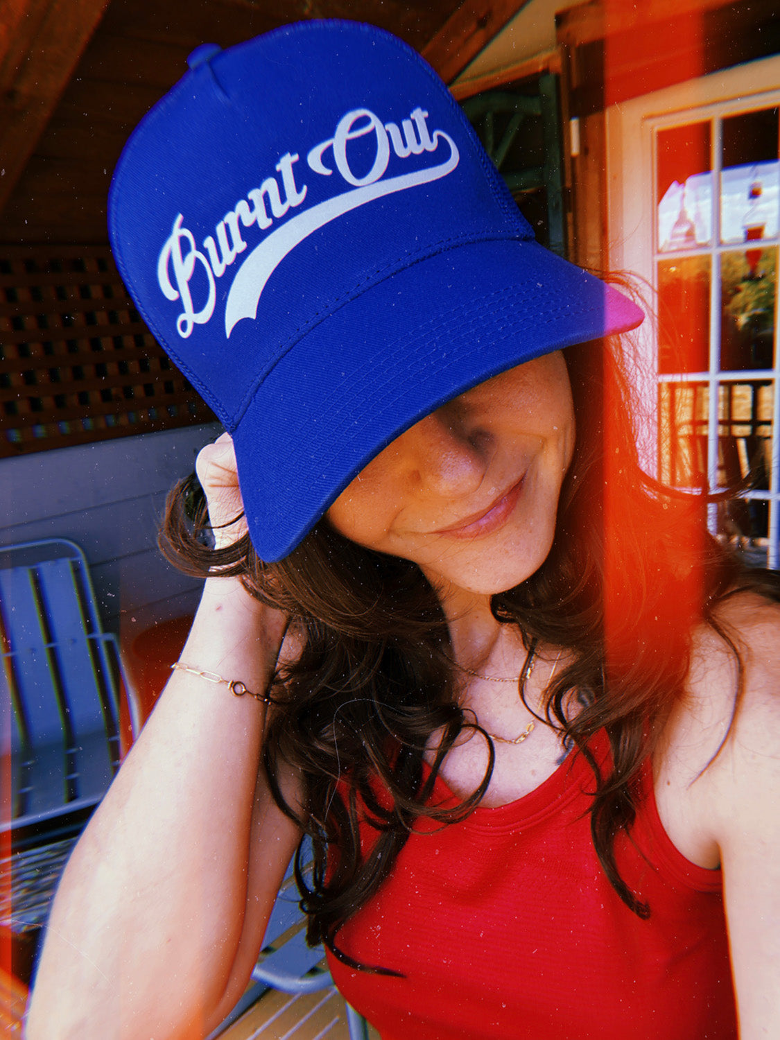 Woman wearing a blue cap with 'Burnt Out' text