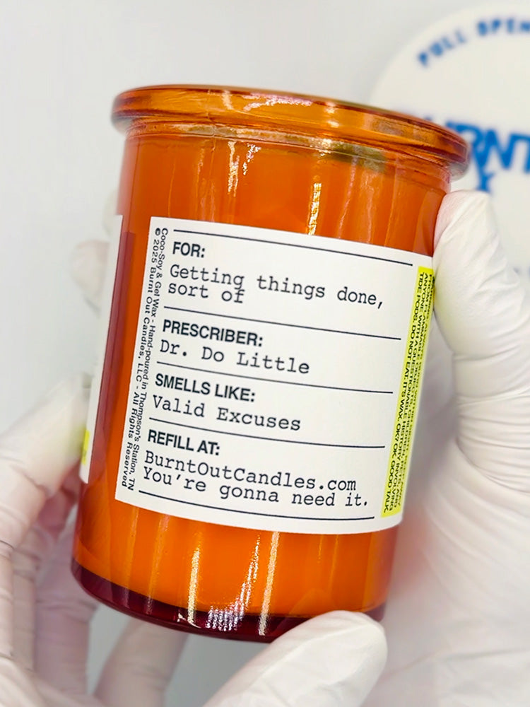 Candle with a humorous label held by a gloved hand